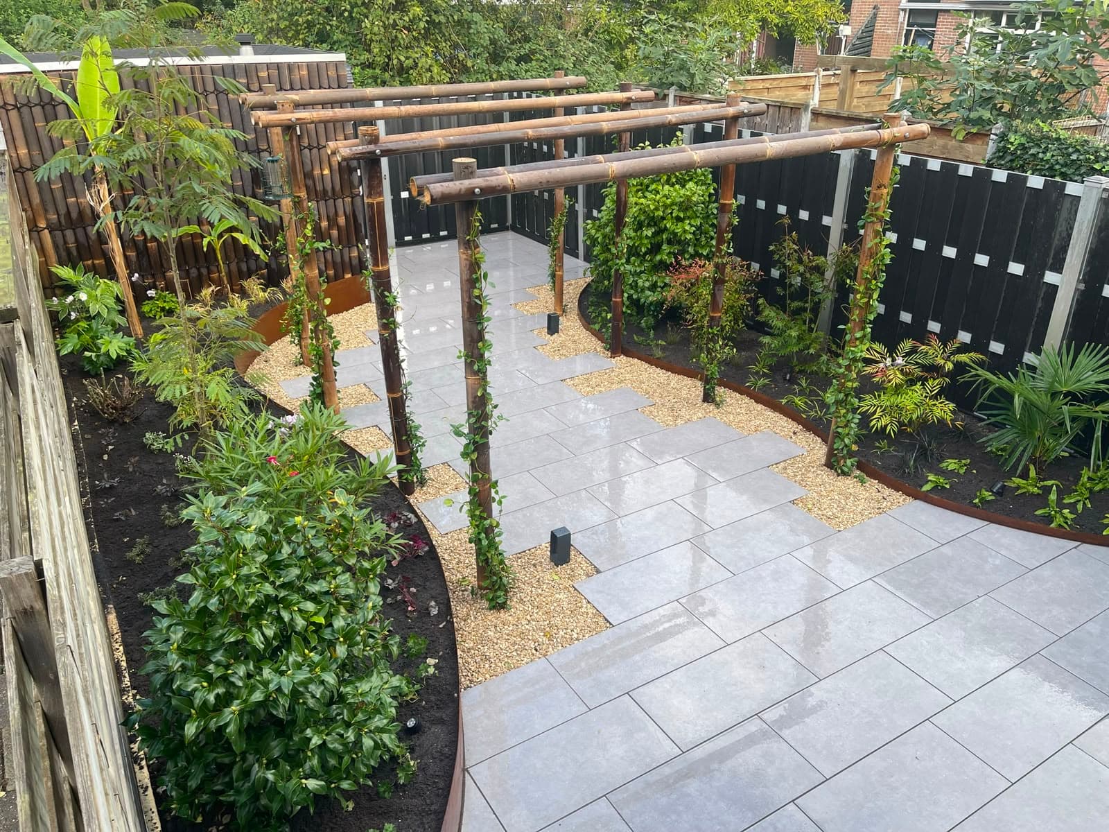Bamboe pergola boven een looppad van tegels en grind